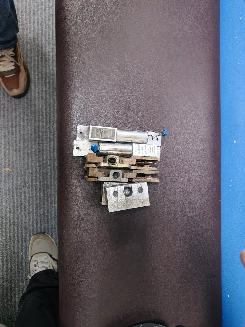 拆下的旧地弹簧与上下门夹配件，液压腔体锈蚀、垫片变形