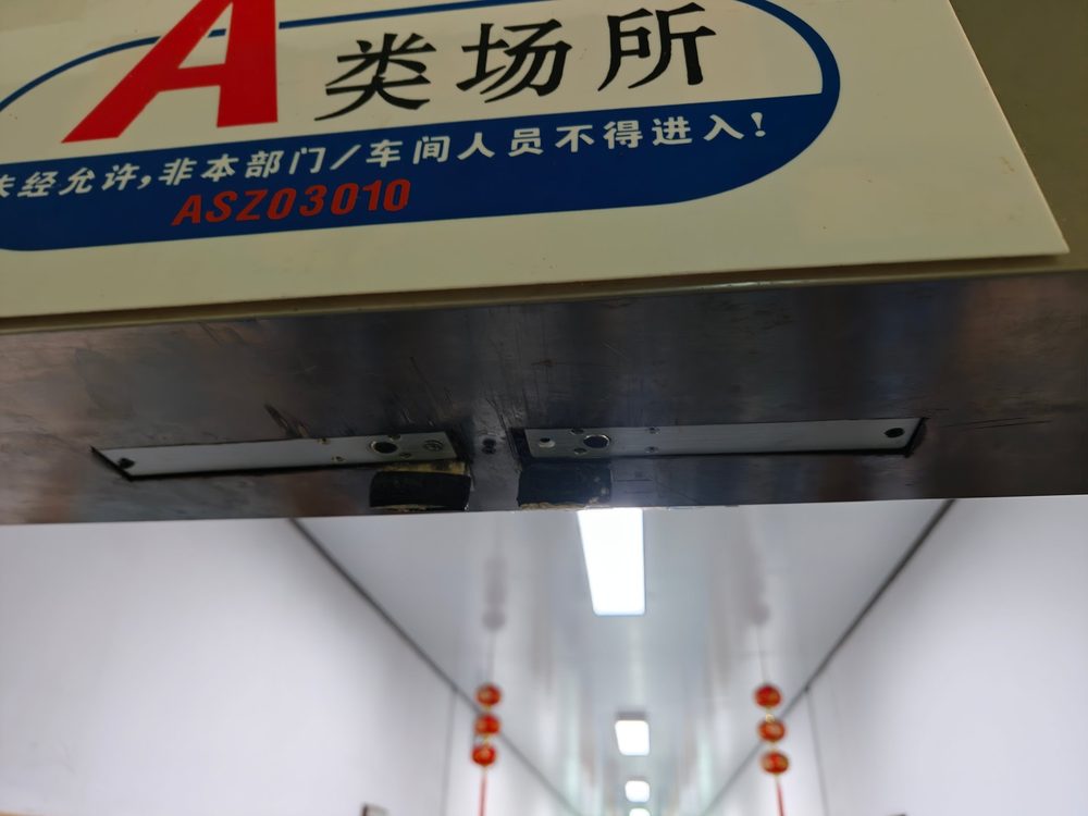 门框顶部上门夹（天轴）安装位，门头设有 A 类场所标识牌